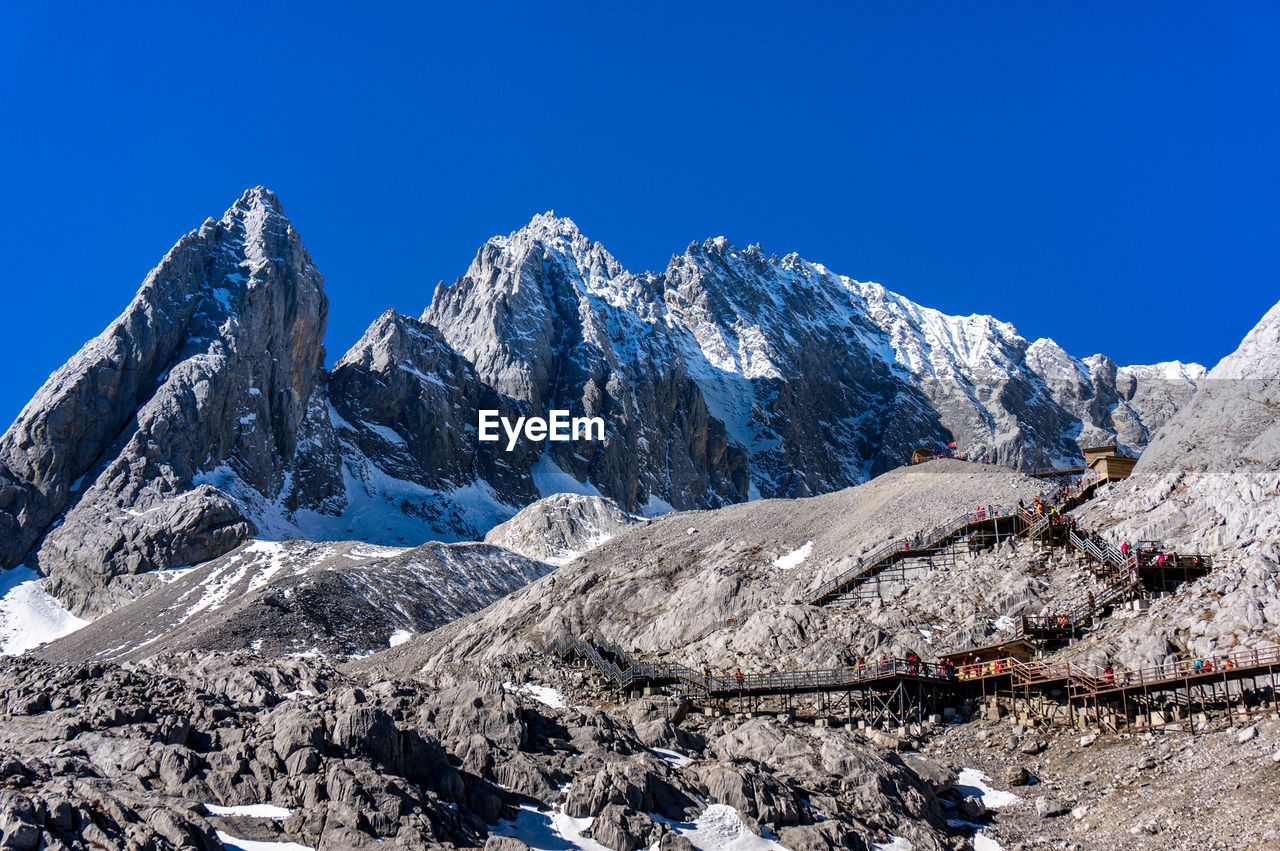 Scenic view of snowcapped mountains against clear blue sky