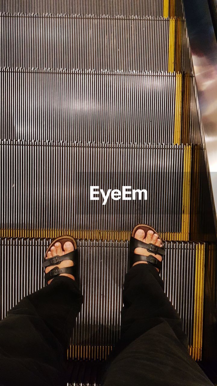 Low section of man on escalator