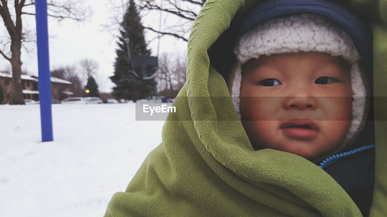 Close-up of toddler with blanket in park