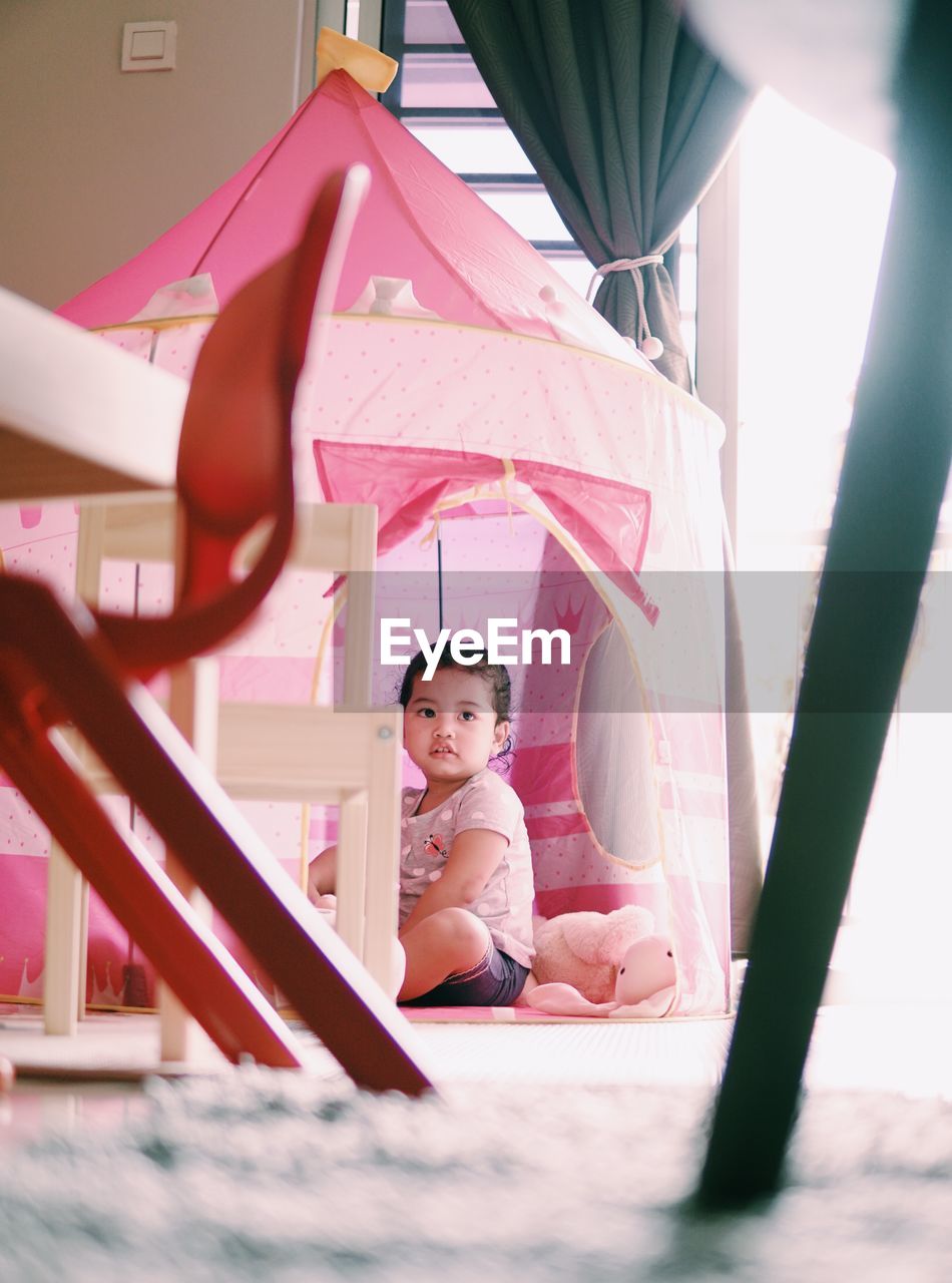 Portrait of girl sitting in pink dress