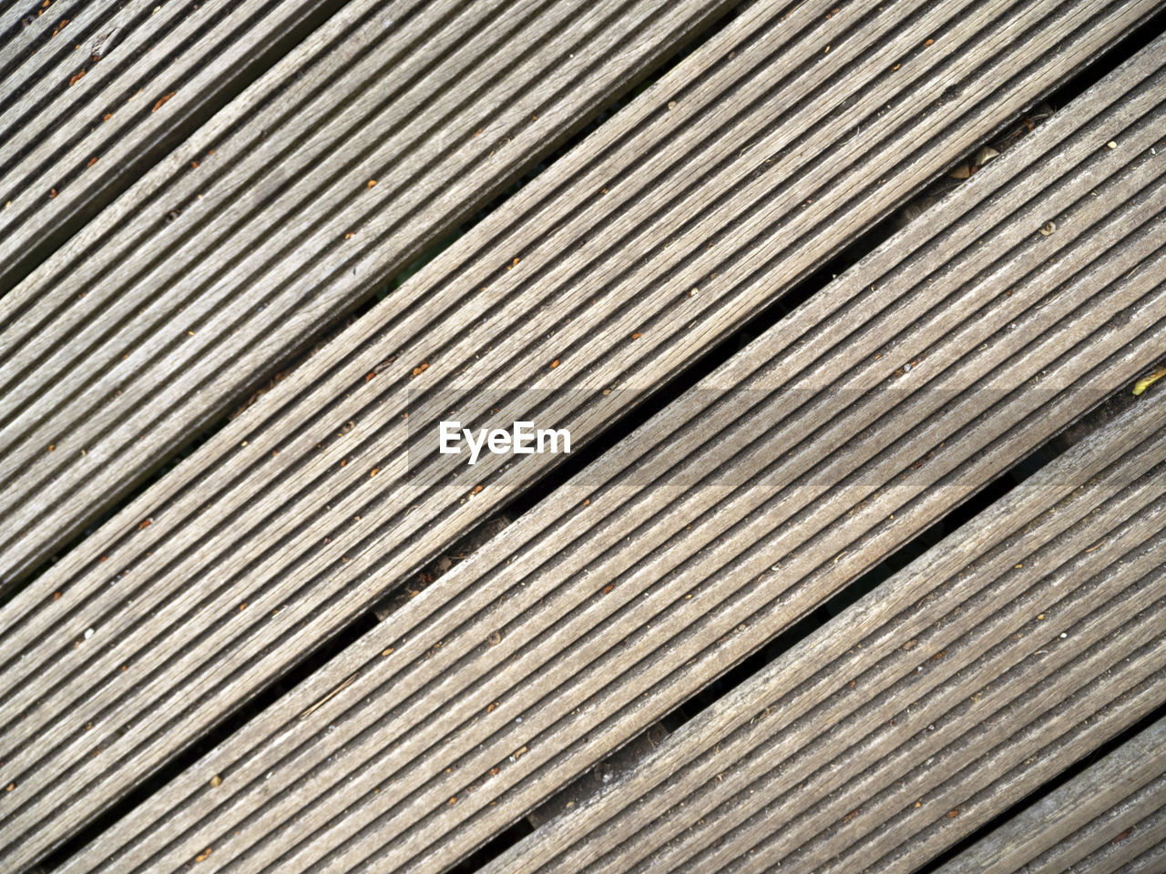 Diagonal closeup shot of wooden decking board suitable for use as a background