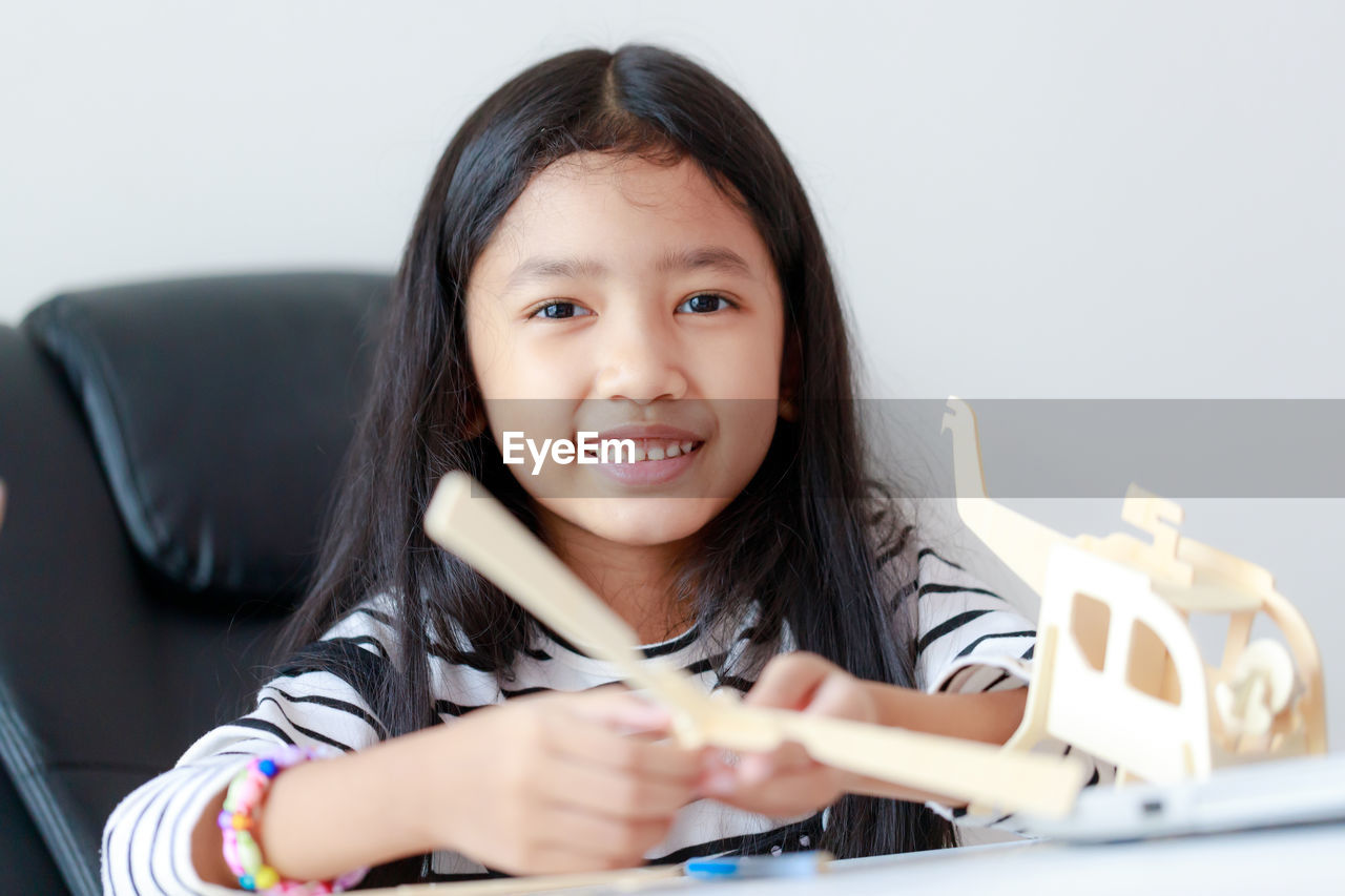 Portrait of smiling girl by toy