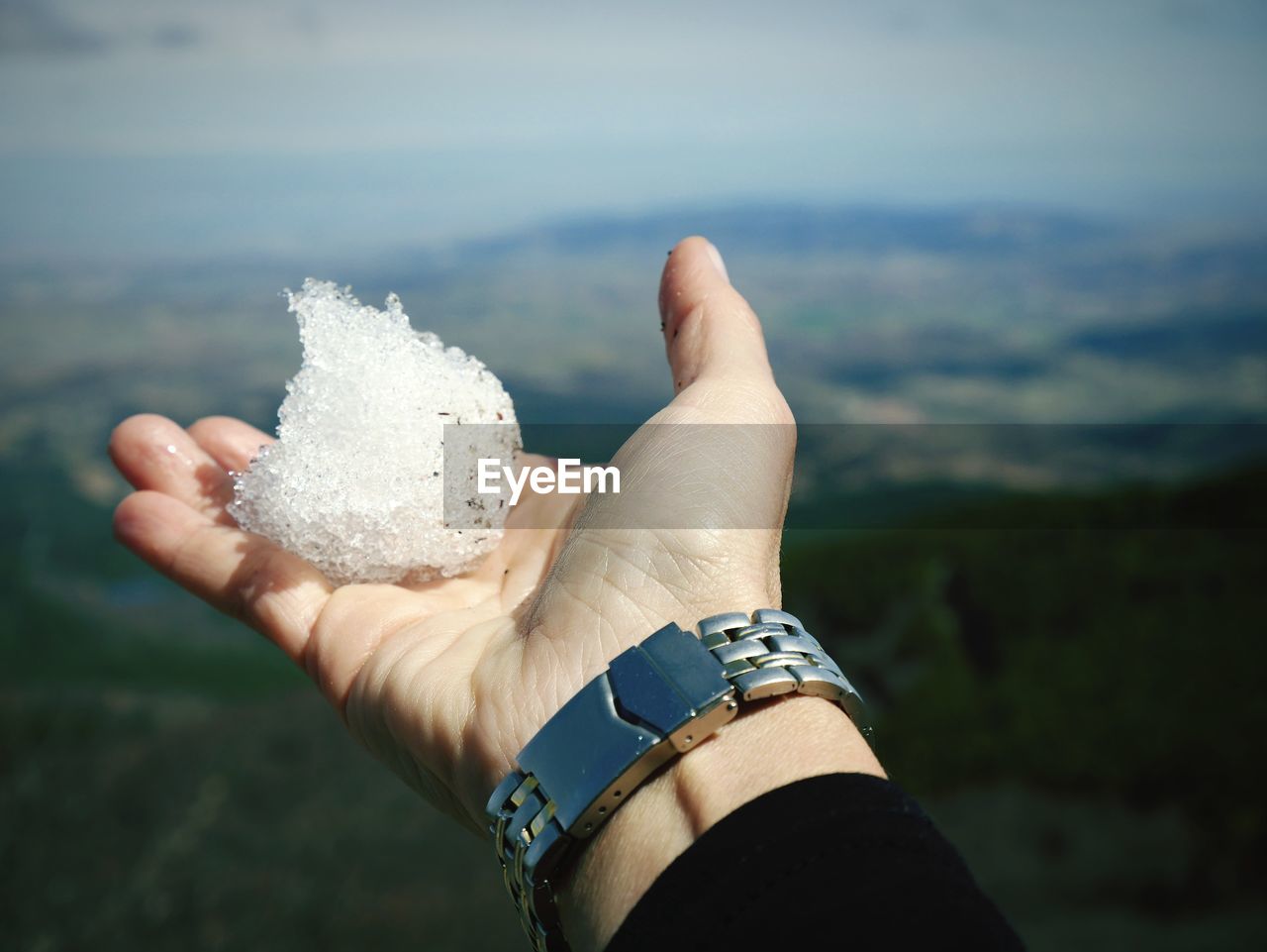 Close-up of human hand holding ice outdoors