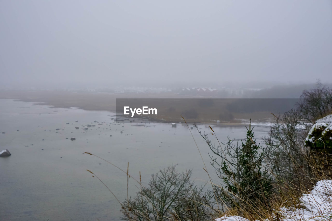 SCENIC VIEW OF FROZEN LAKE AGAINST SKY