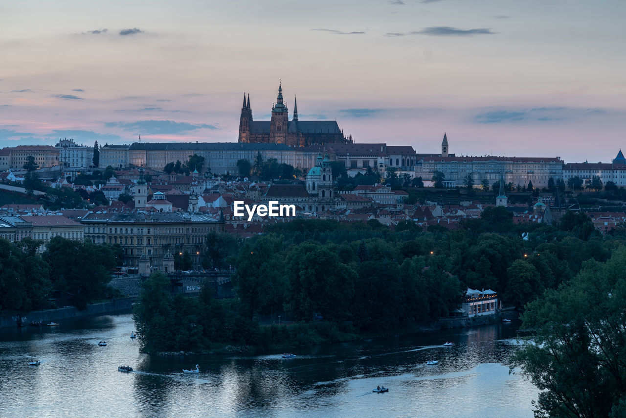 High angle view of river in city against sky during sunset