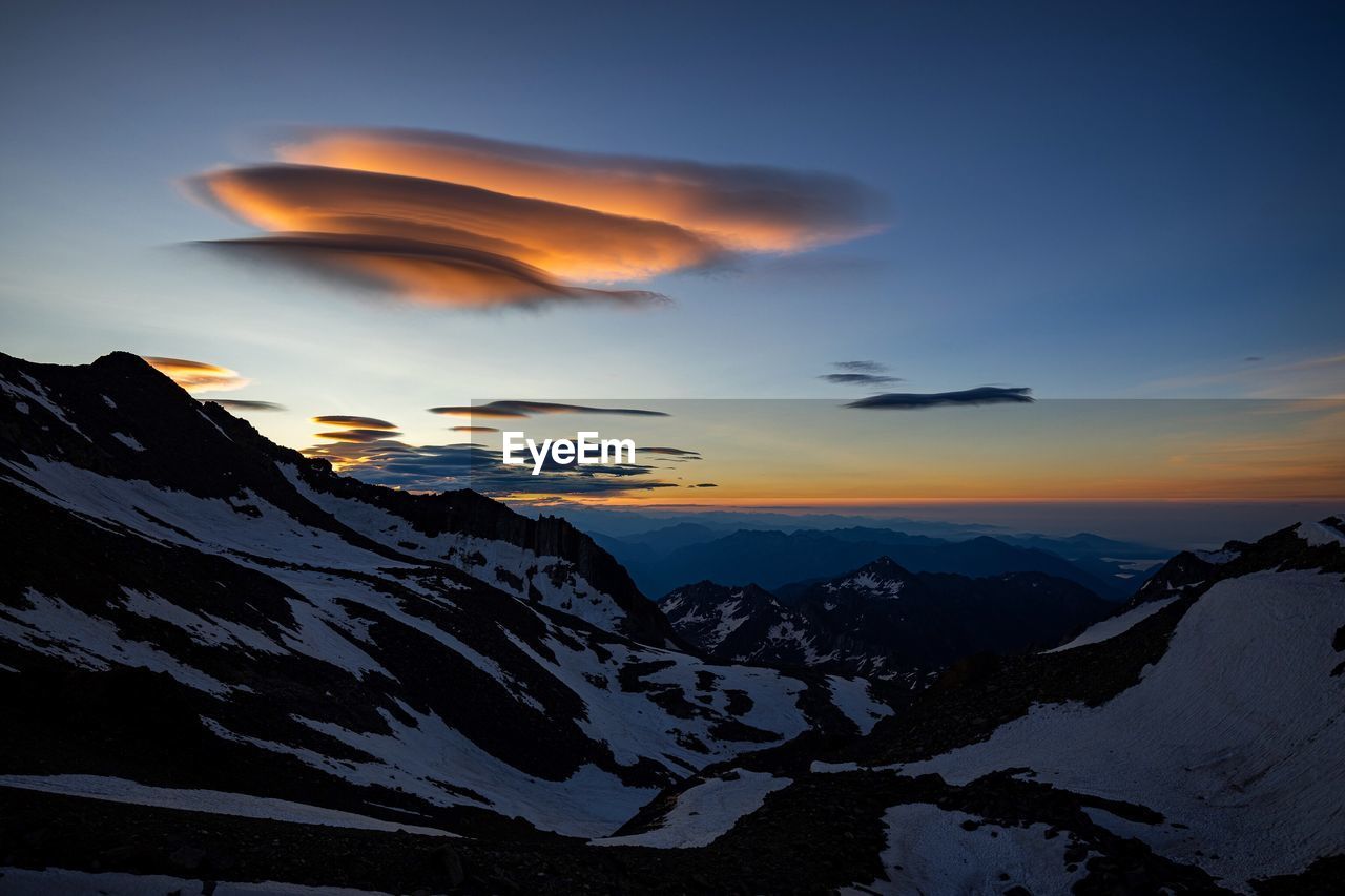 Scenic view of snowcapped mountains against sky during sunset