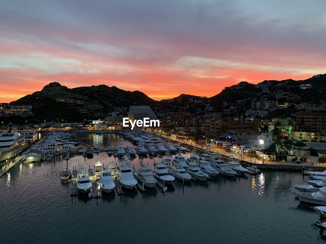 Cabo san lucas marina at sunset after a busy day the many boats and yachts moored up 