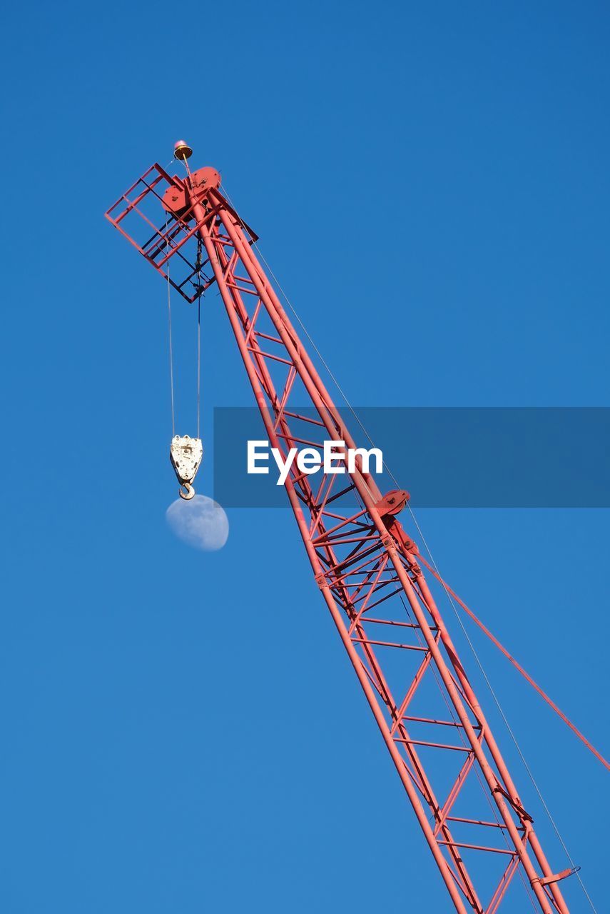 LOW ANGLE VIEW OF CRANE AT CONSTRUCTION SITE AGAINST CLEAR BLUE SKY