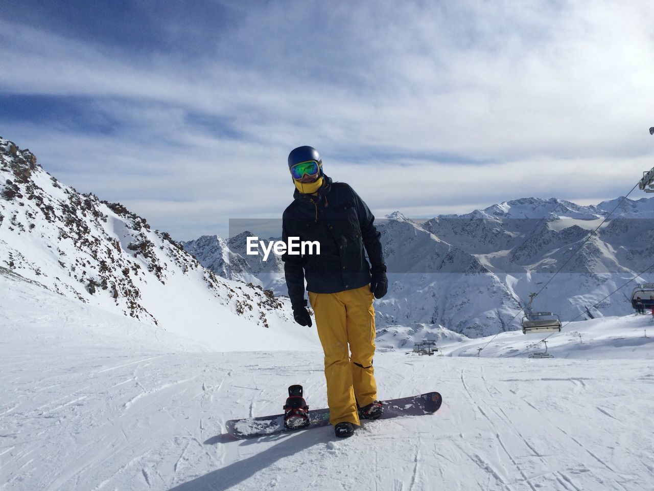 Full length of person with ski on snowfield against cloudy sky