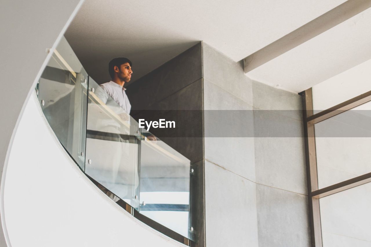 Young man leaning on railing