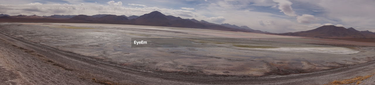 PANORAMIC SHOT OF LAND AND MOUNTAINS AGAINST SKY