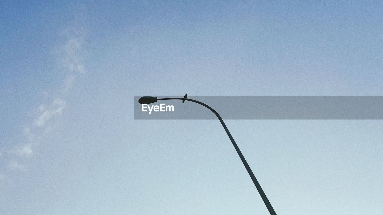Low angle view of street light against blue sky