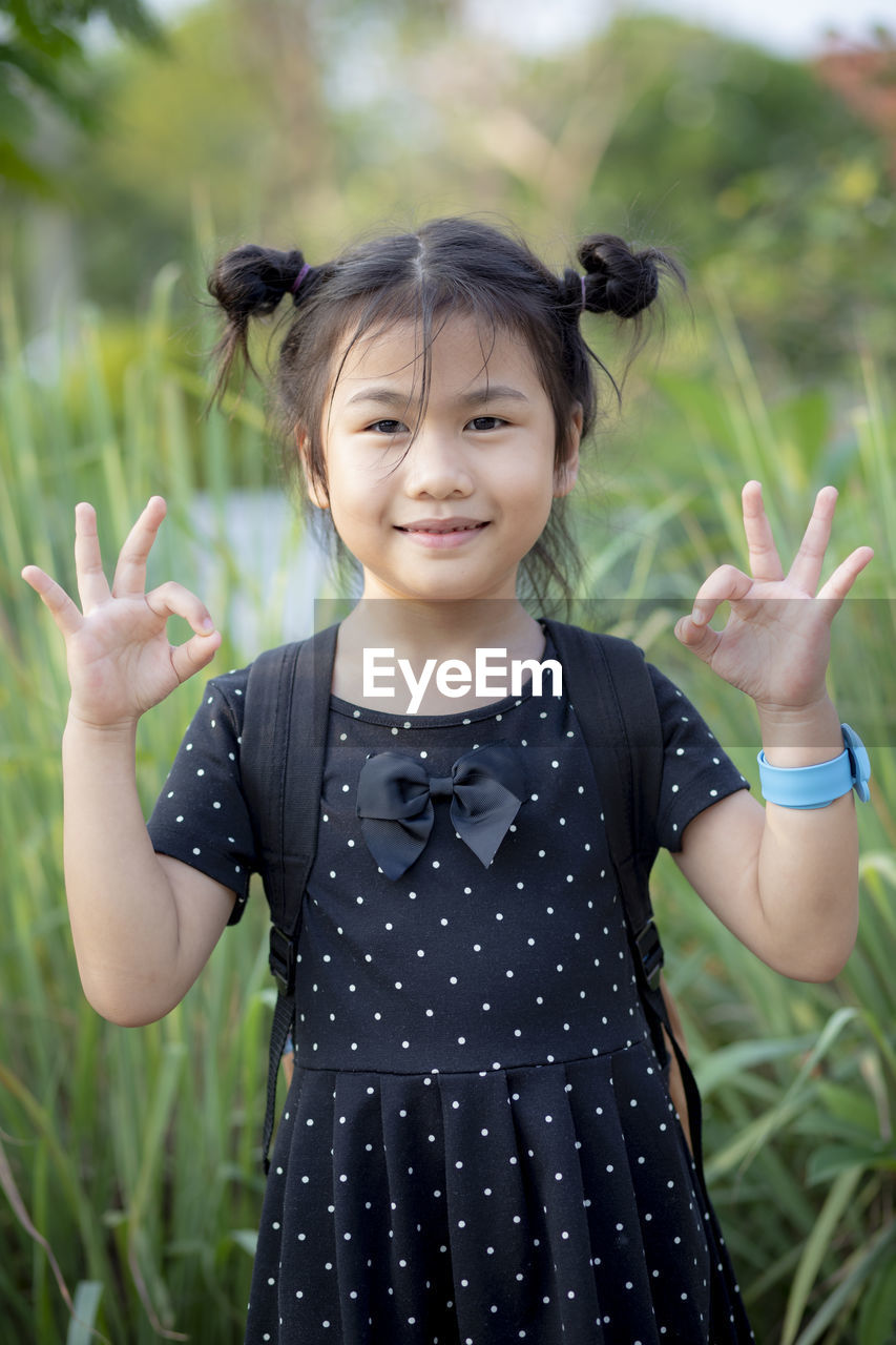 Portrait of smiling girl standing in field