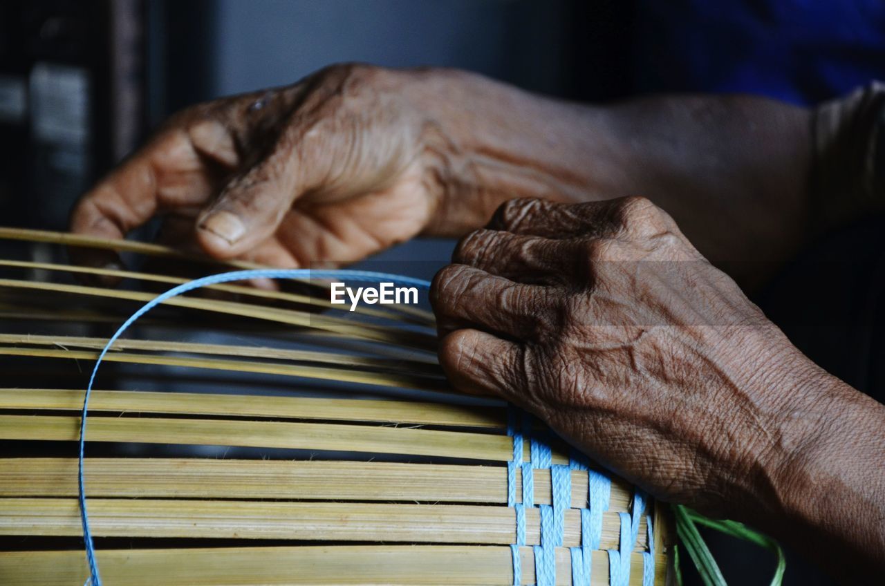 Close-up of hands making basket