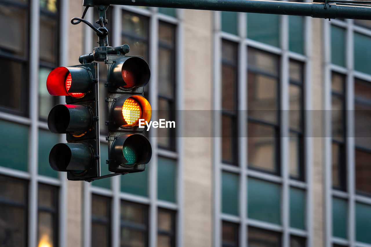 LOW ANGLE VIEW OF ROAD SIGNAL AT NIGHT