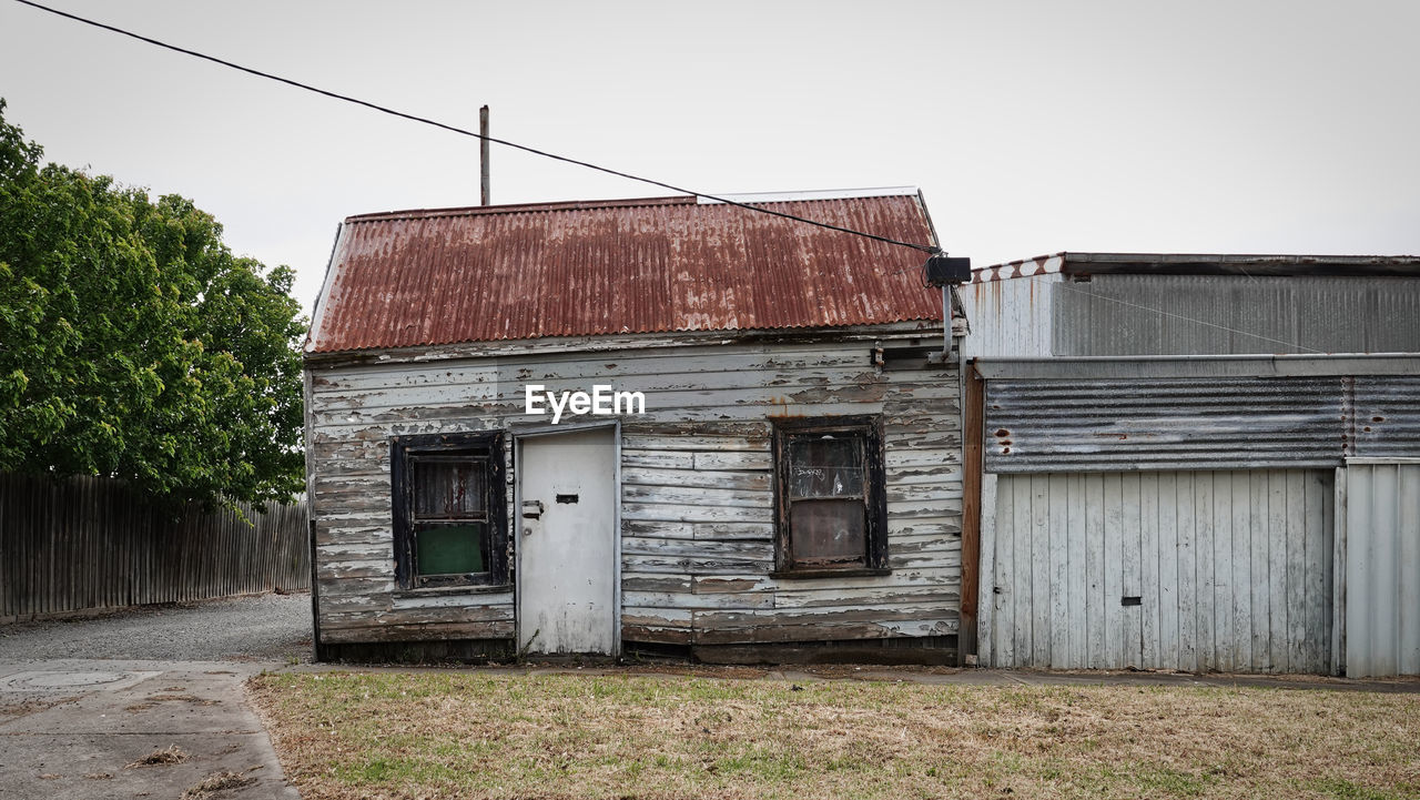 EXTERIOR OF ABANDONED BUILDING AGAINST SKY