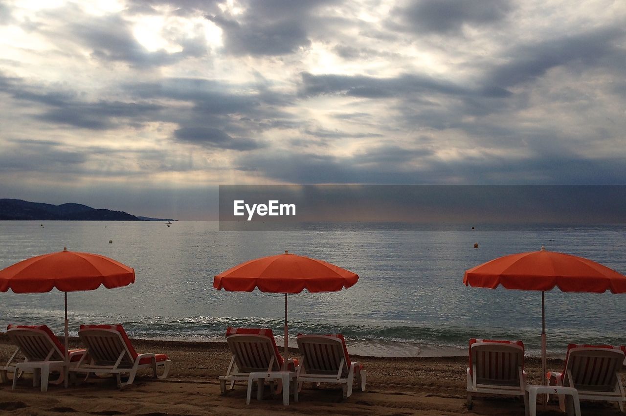 VIEW OF CHAIRS ON BEACH AGAINST SKY