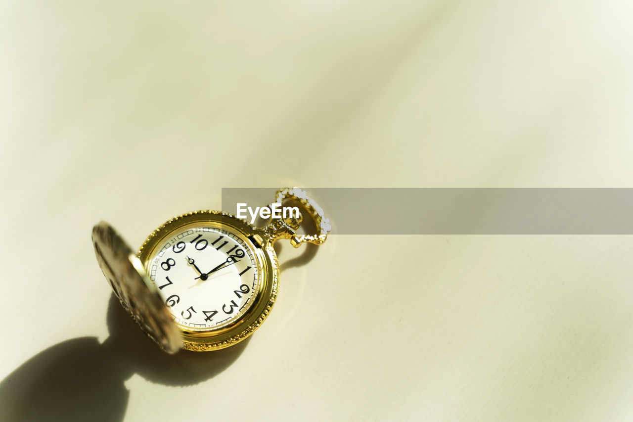 Close-up of clock over yellow background