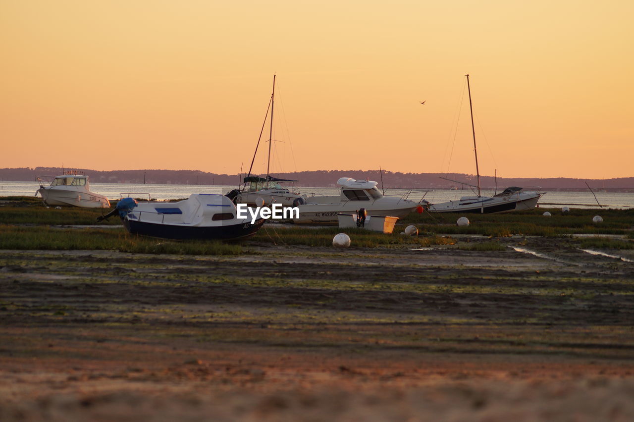 BOATS IN SEA AT SUNSET