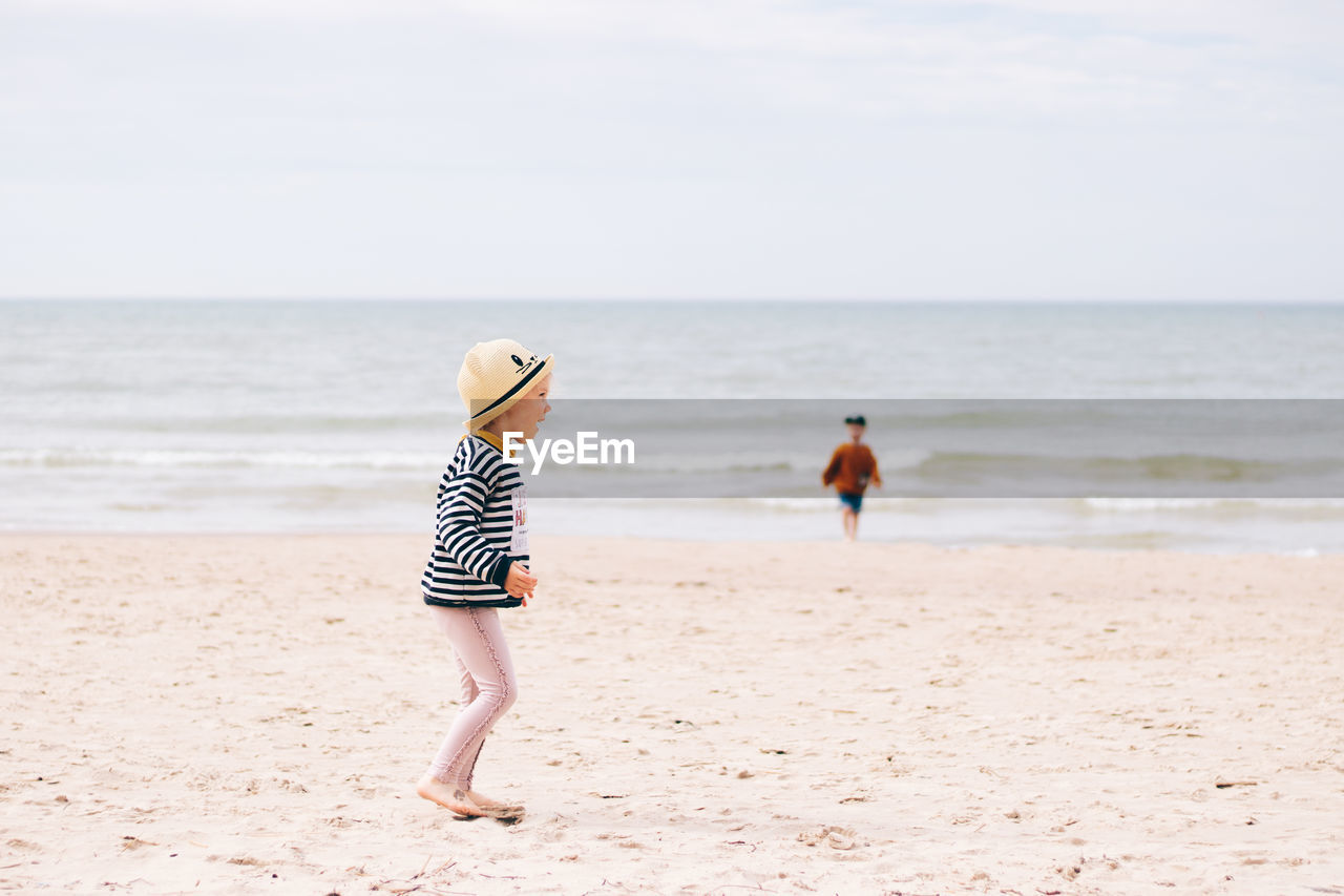 REAR VIEW OF FRIENDS ON BEACH