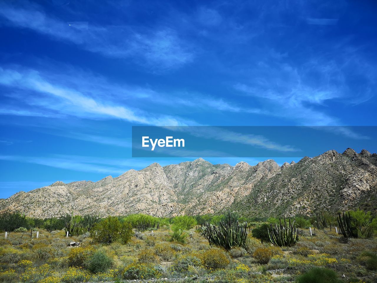 Scenic view of mountain against blue sky