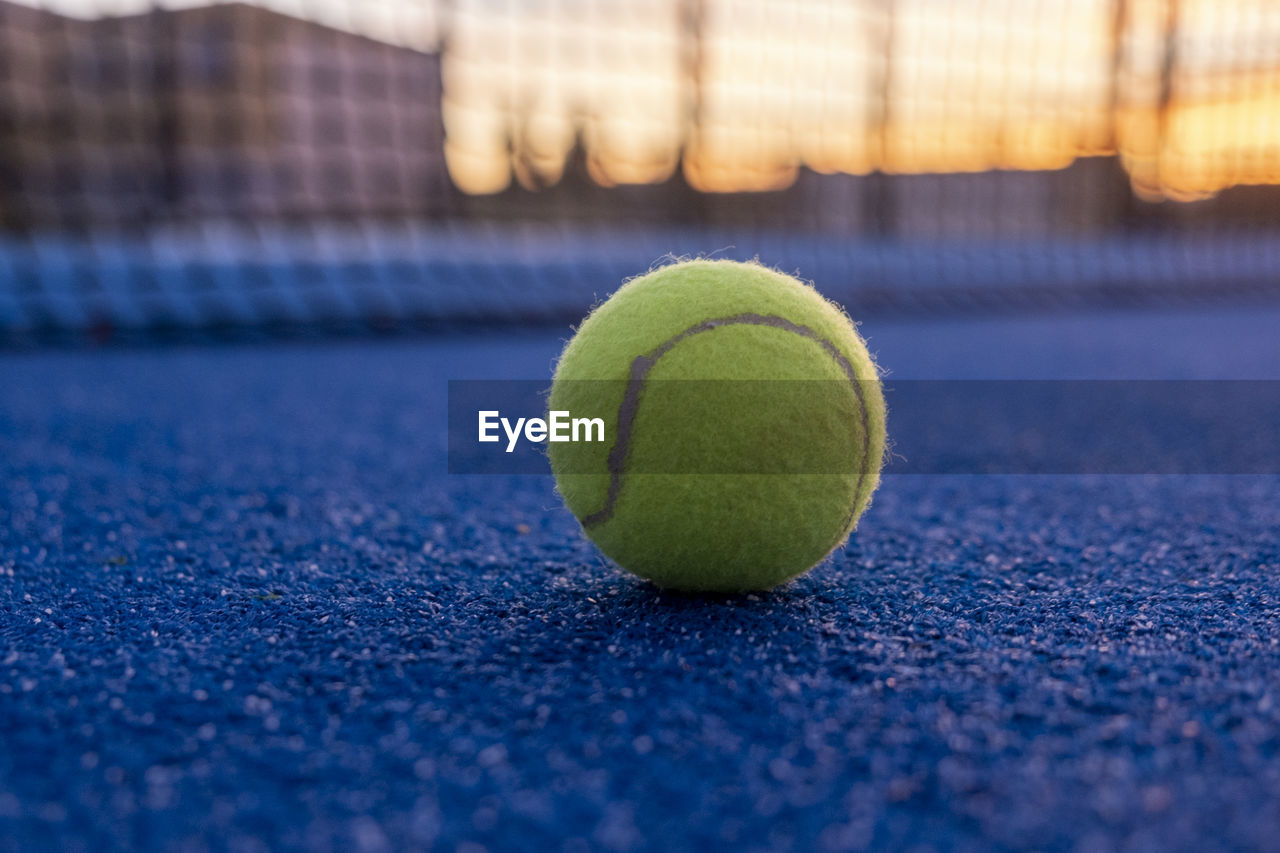 tennis, tennis ball, sports, ball, green, tennis net, selective focus, racket, no people, yellow, tennis racket, sports equipment, sphere, close-up, leisure activity, competition, racket sport, single object, blue, recreation, net - sports equipment