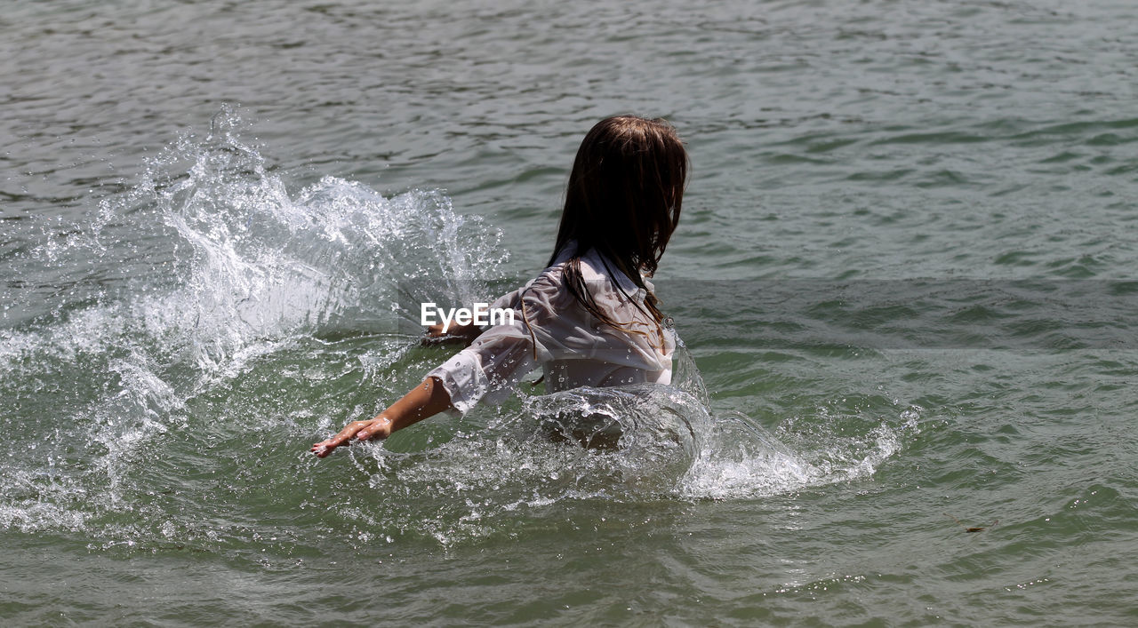 REAR VIEW OF WOMAN IN SEA WATER