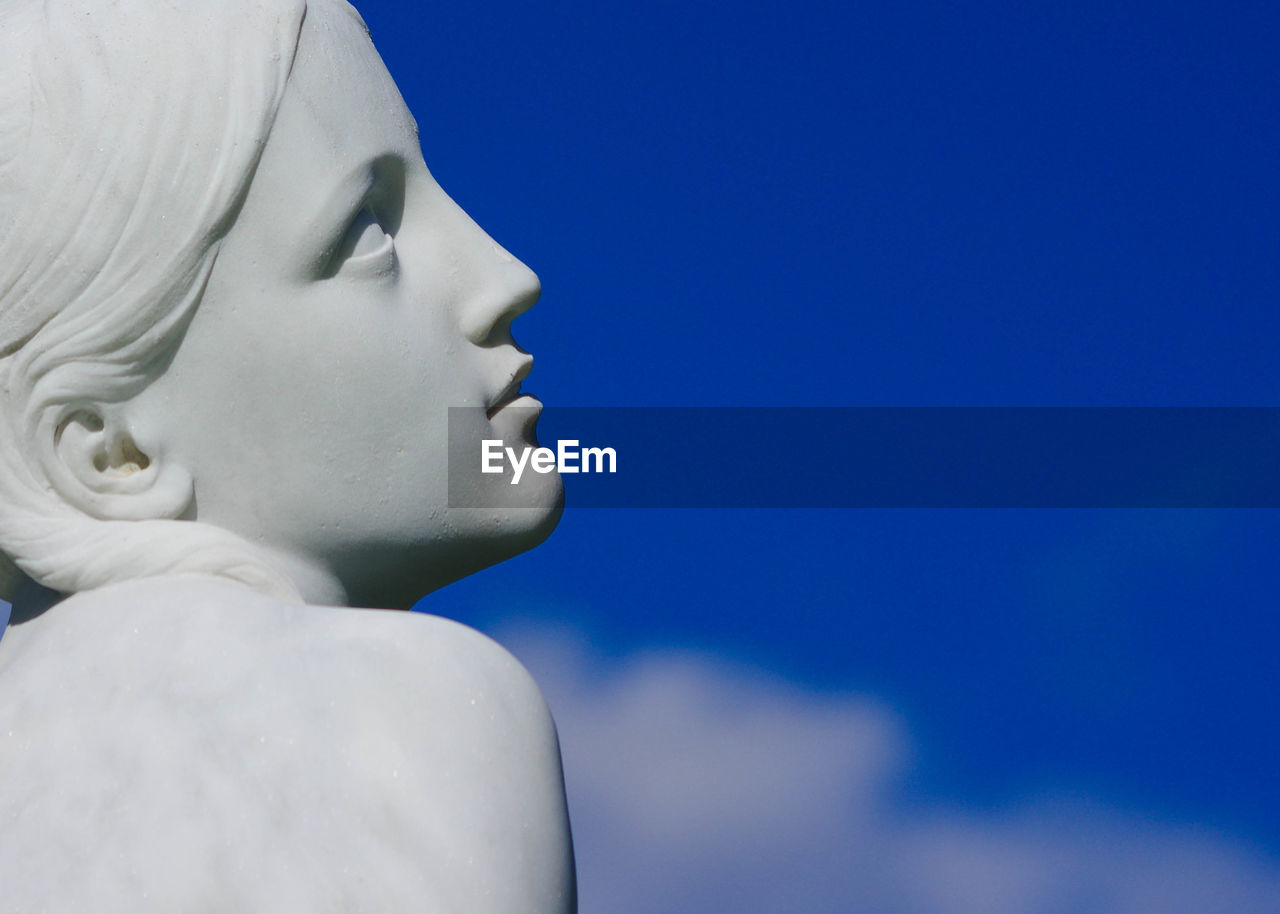 CLOSE-UP OF STATUE AGAINST CLEAR BLUE SKY