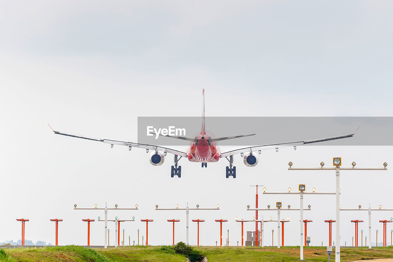 Low angle view of airplane landing against sky