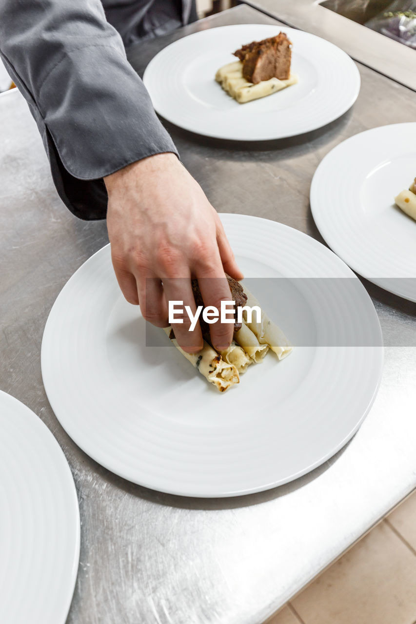 midsection of man preparing food in plate