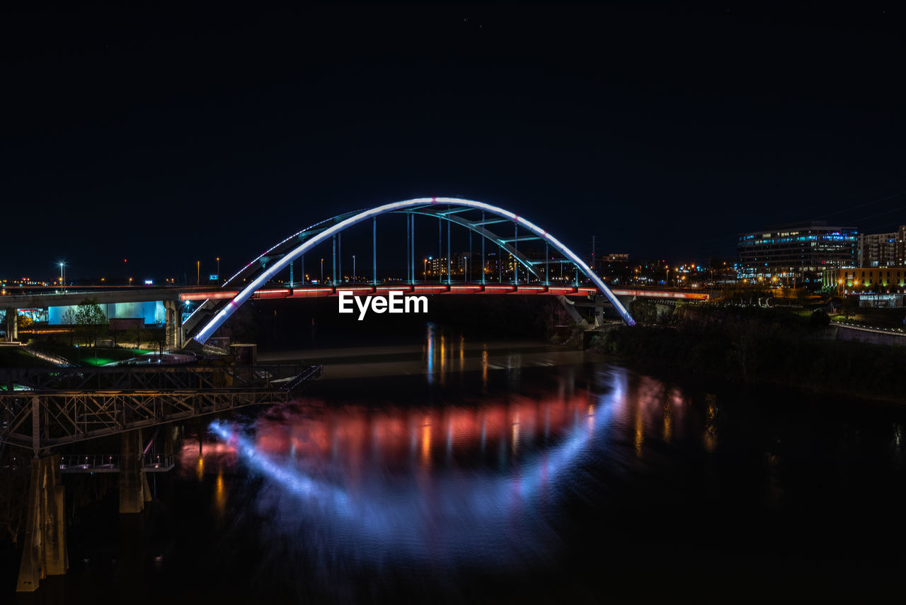 View of bridge over river at night