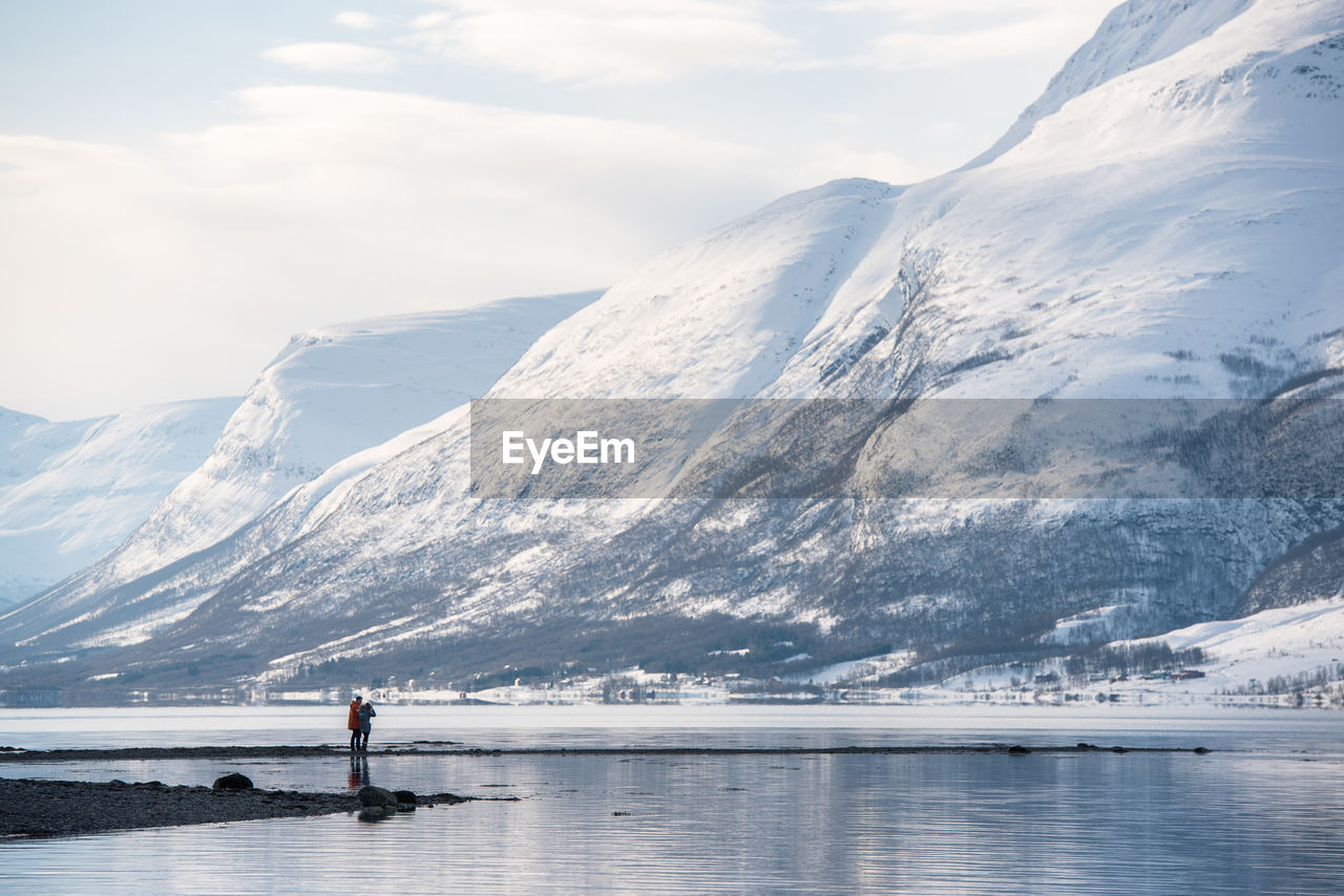 Scenic view of lake against mountains during winter