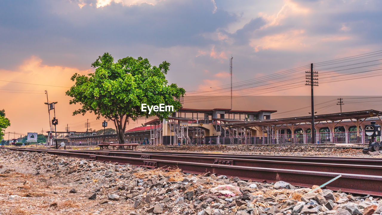 VIEW OF RAILROAD TRACKS AGAINST SKY DURING SUNSET