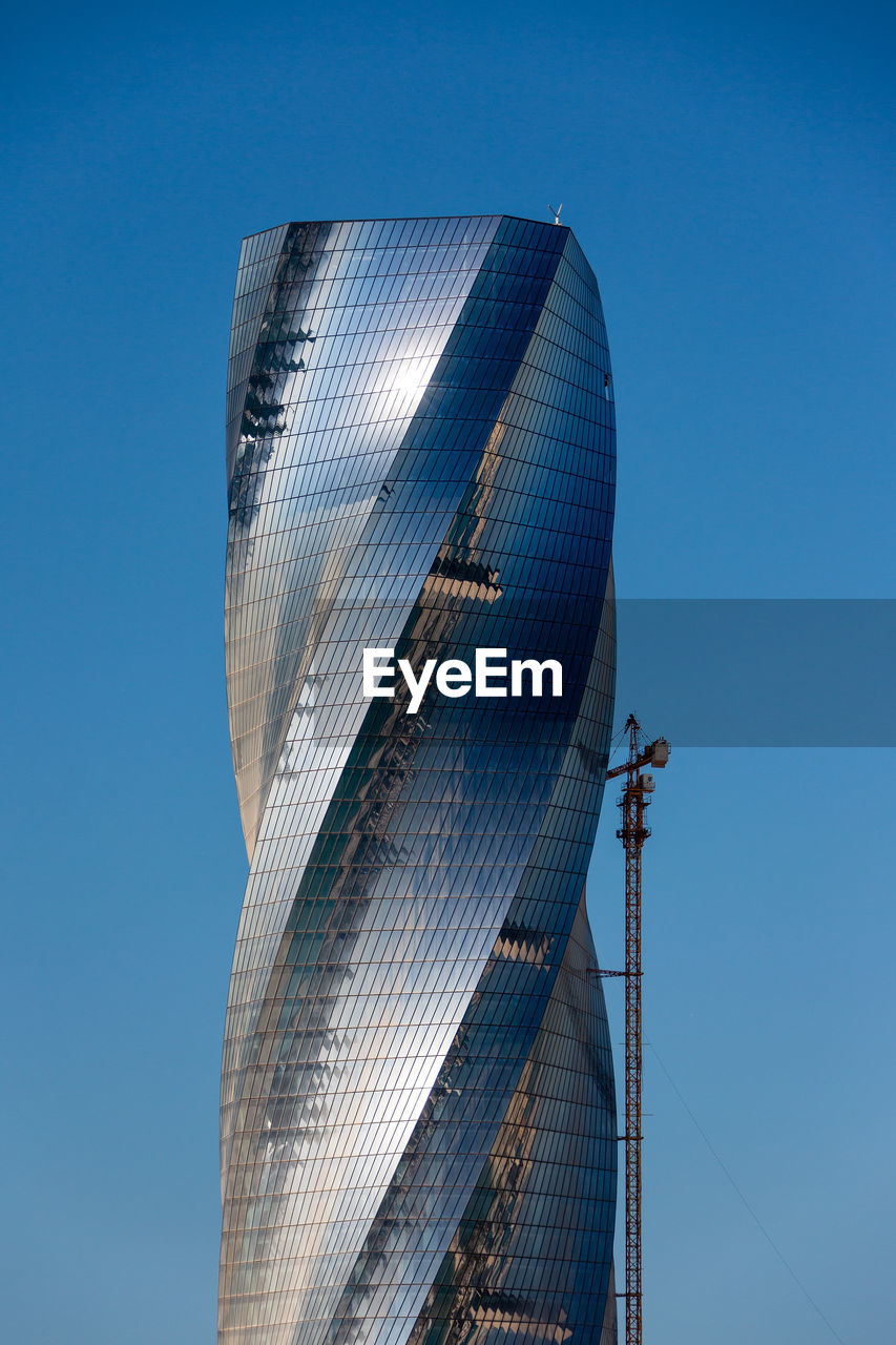 Low angle view of modern buildings against blue sky