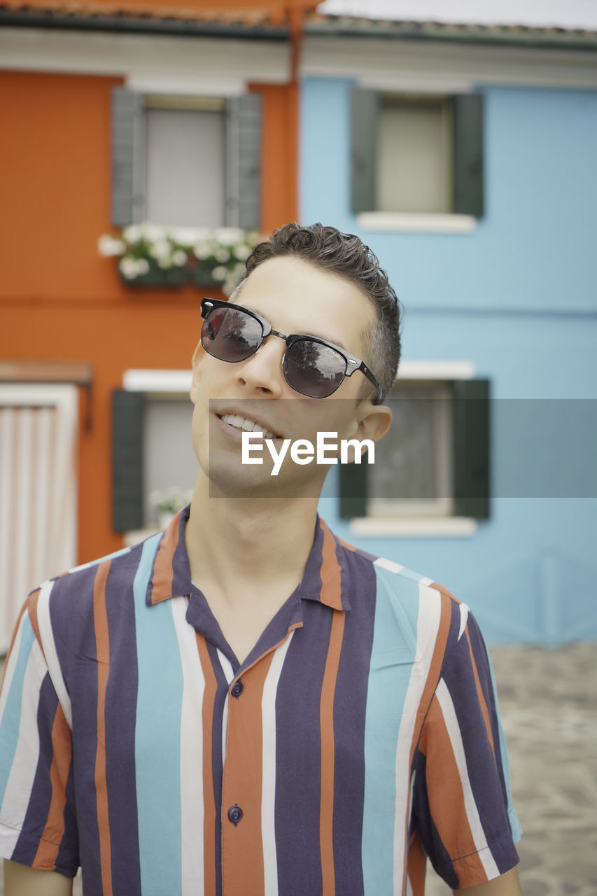 Portrait of young man wearing sunglasses standing outdoors