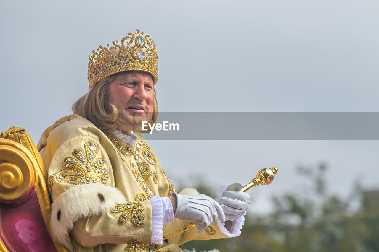 crown, adult, one person, royalty, smiling, clothing, person, happiness, portrait, men, emotion, gold, history, fashion accessory, copy space, the past, headwear, nature, traditional clothing, waist up, sky, architecture, king, senior adult, facial hair, cheerful, holding, day, outdoors, beard, looking at camera