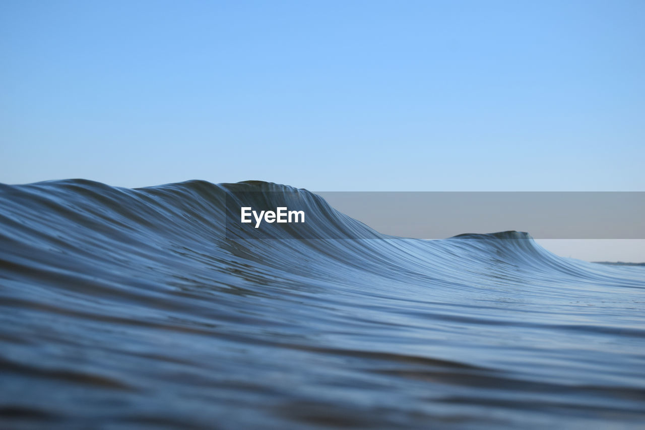 Sea waves against clear blue sky