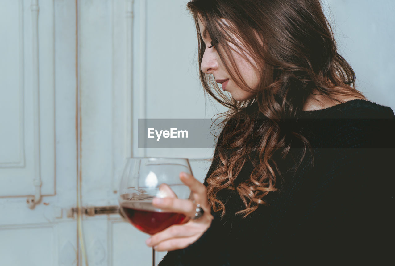 Woman having red wine at home