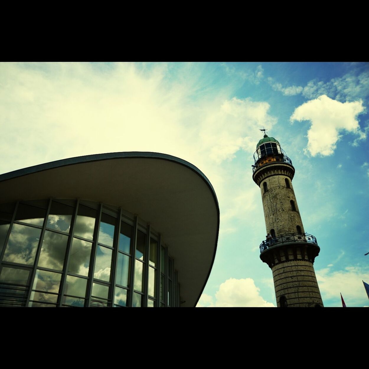 LOW ANGLE VIEW OF MODERN OFFICE BUILDING AGAINST CLOUDY SKY