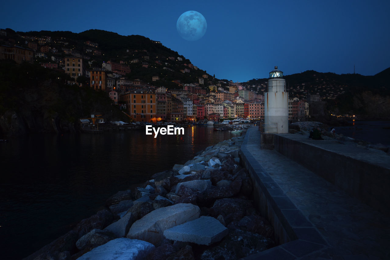 Incredible full moon in camogli in front of the lighthouse