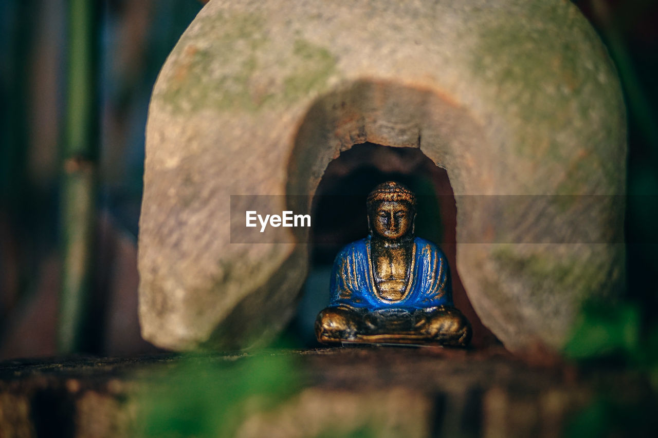 CLOSE-UP OF STATUE OF BUDDHA AGAINST BUILDING