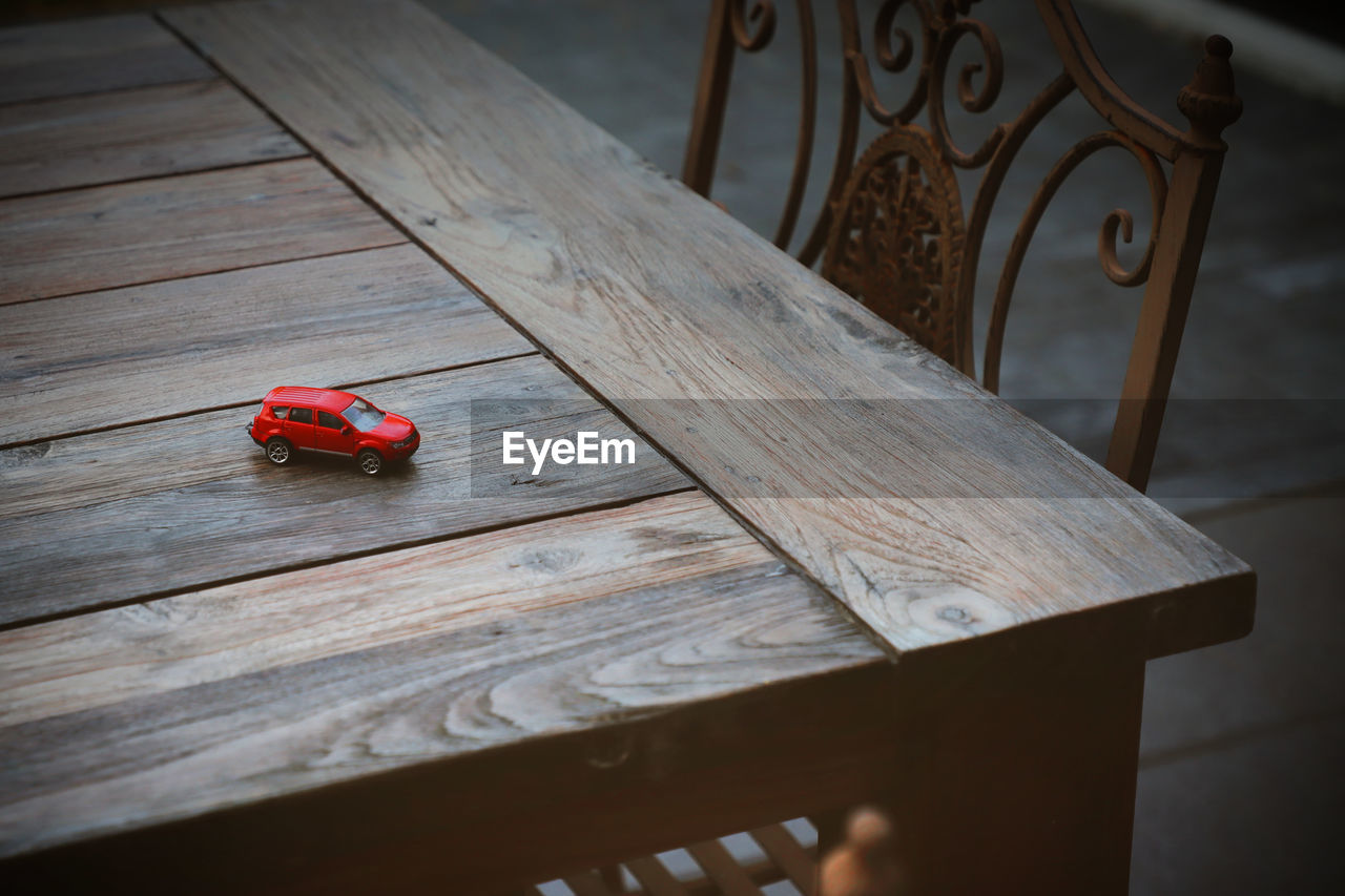 Red Toy Car Bench Chair Childhood Close-up Day Flooring Focus On Foreground High Angle View Metal Nature No People Outdoors Pattern Plank Red Red Car Seat Selective Focus Still Life Table Toy Wood Wood - Material