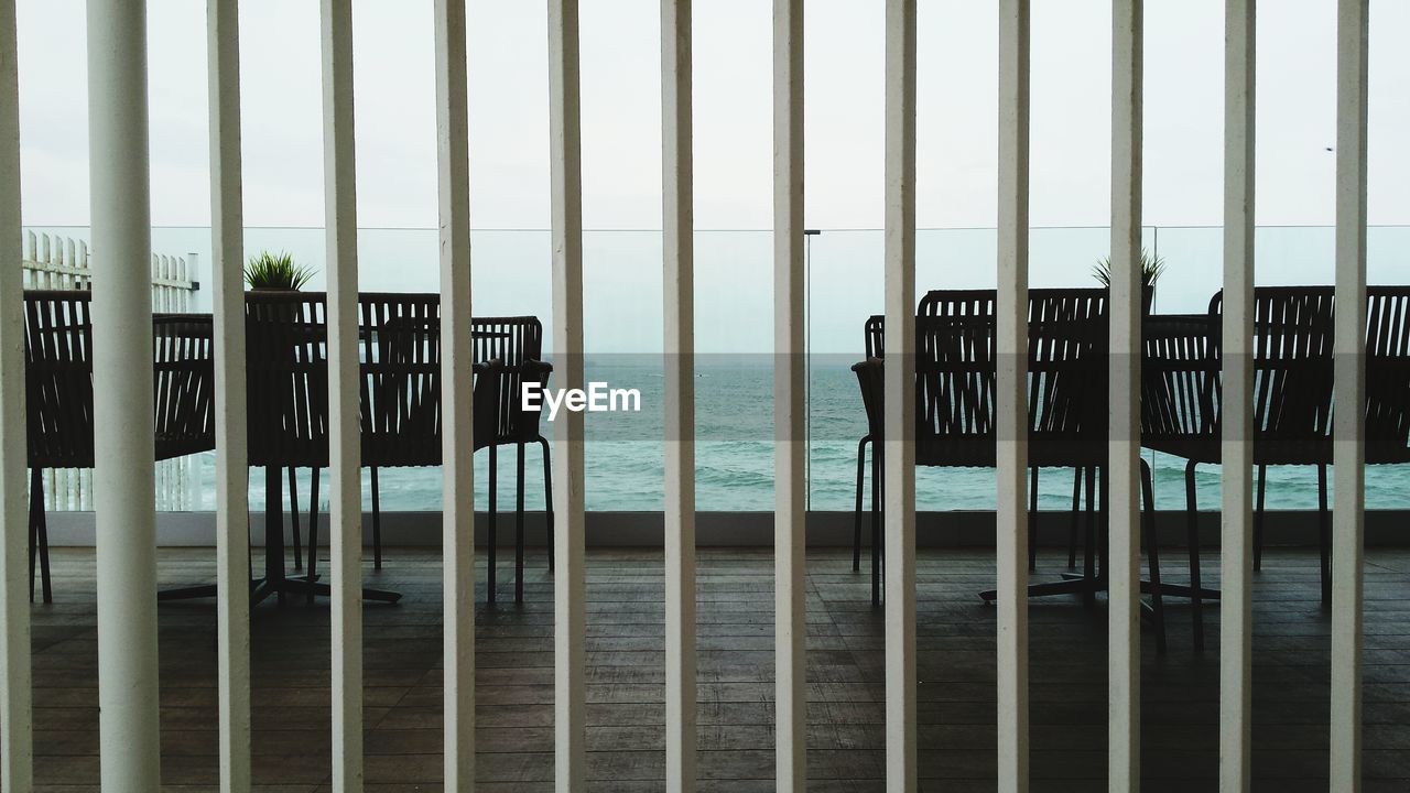 Chairs and table in balcony seen through window