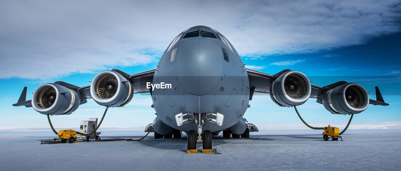 Low angle view of airplane on airport runway against sky