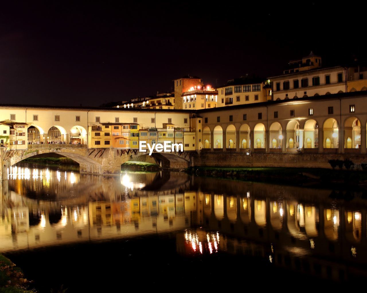 REFLECTION OF ILLUMINATED BUILDINGS IN RIVER AT NIGHT