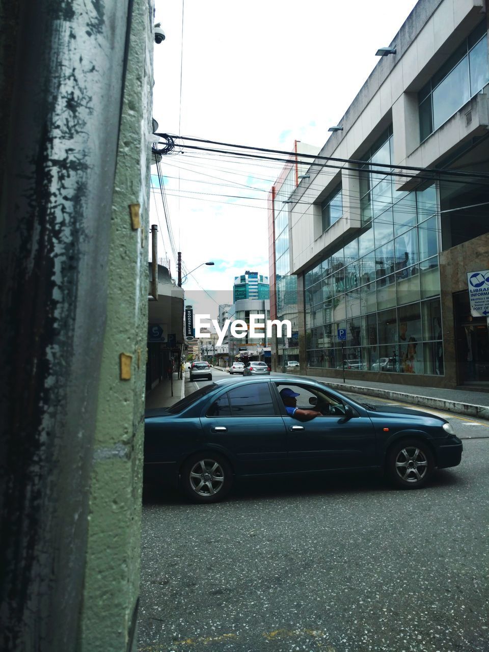 CARS ON ROAD AMIDST BUILDINGS IN CITY