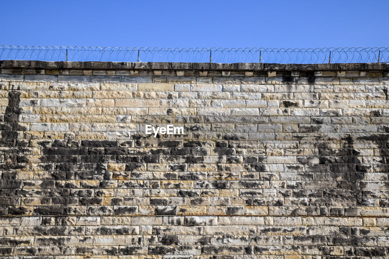 Abandoned prison wall brick and blue sky