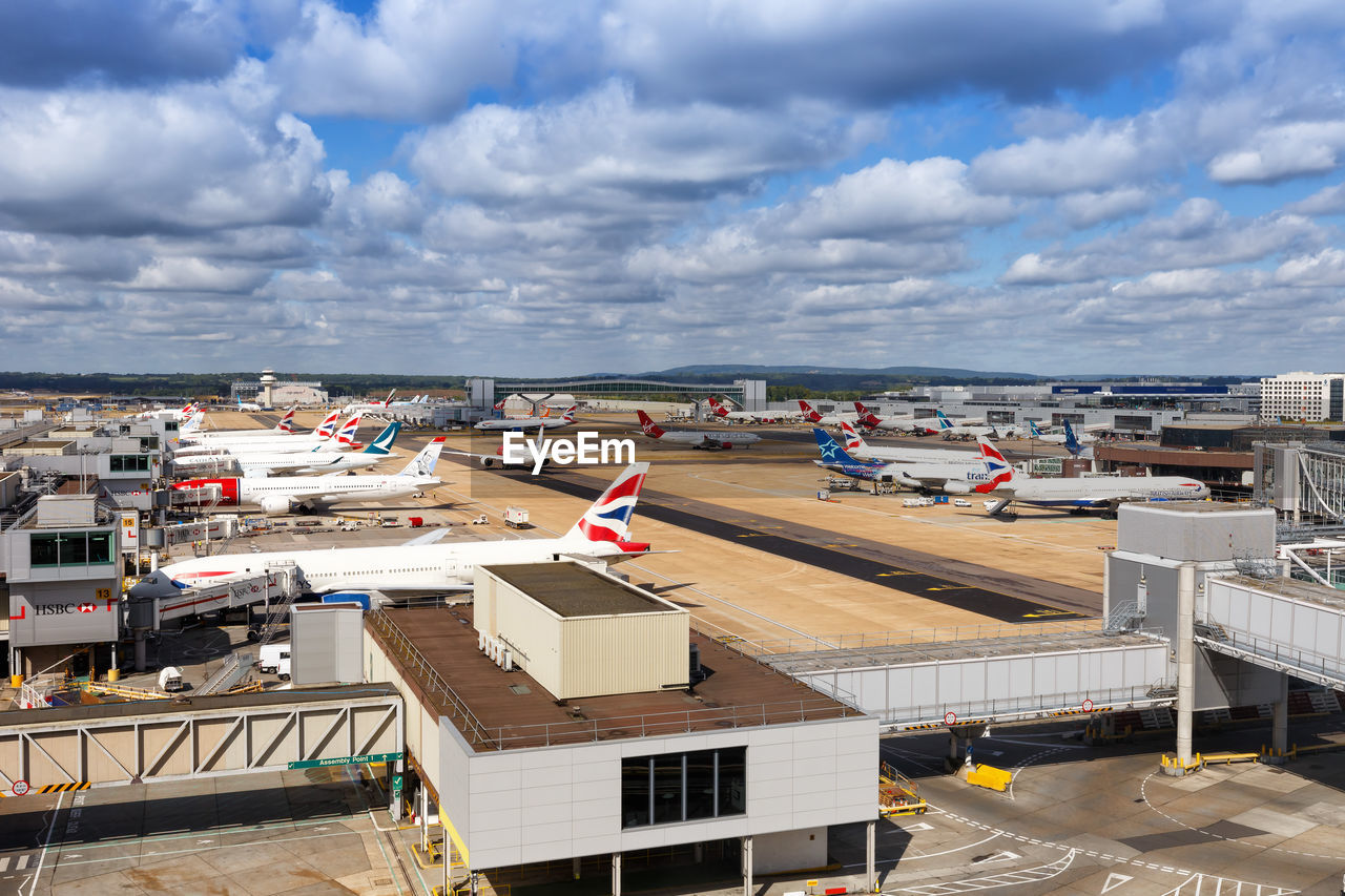 HIGH ANGLE VIEW OF AIRPORT AND SEA AGAINST SKY