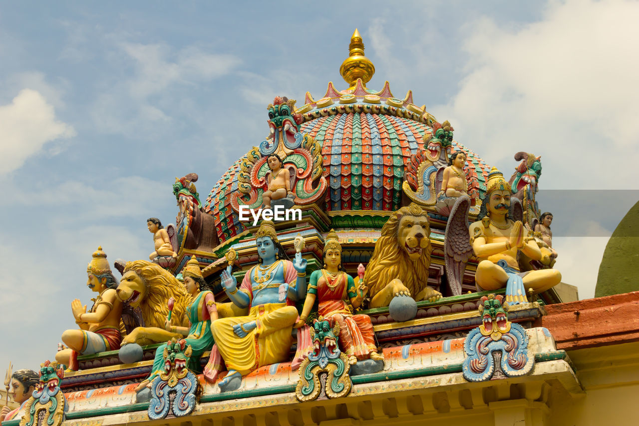 LOW ANGLE VIEW OF STATUE AGAINST TEMPLE