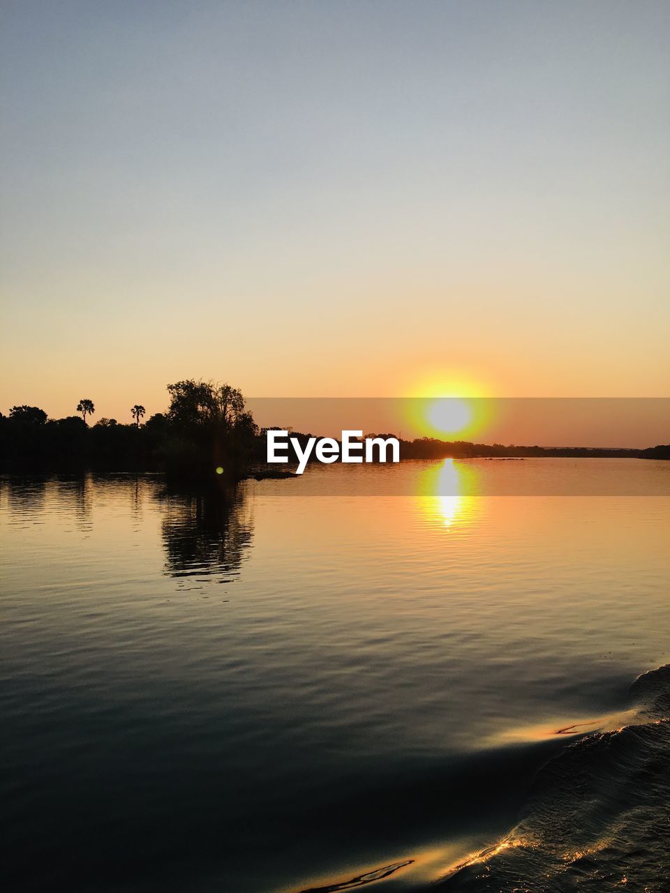 SCENIC VIEW OF LAKE AGAINST SKY AT SUNSET